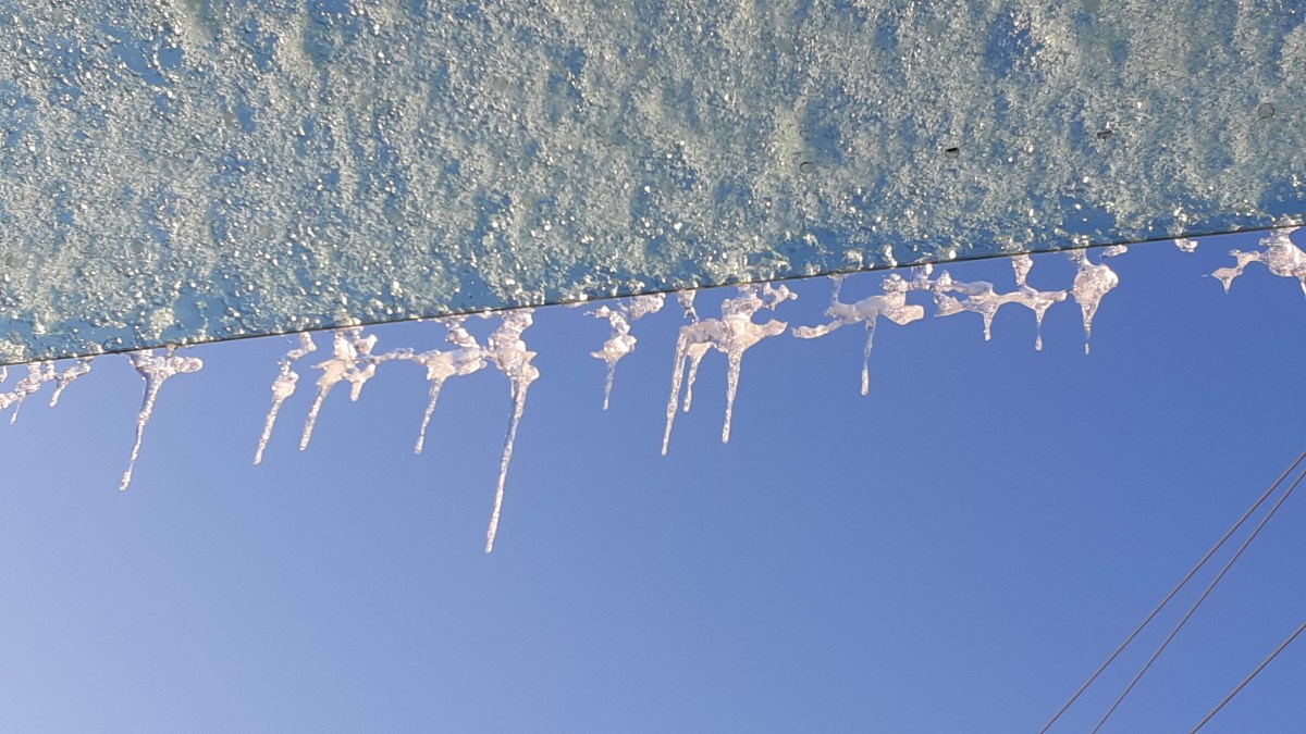 Icicles hanging from the roof of a bus shelter